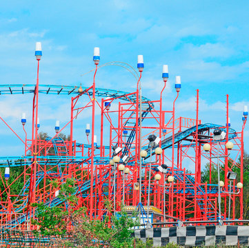 red roller coaster under a blue sky