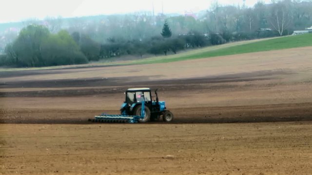 Traktor plows the land in spring