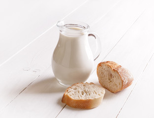 Milk in glass jug and bread