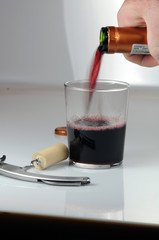 Rotwein in Glas eingießen