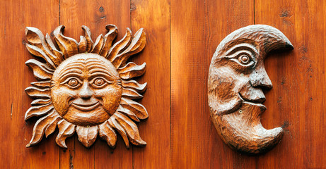 Ancient door with Moon and Sun face carved from wood