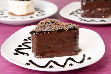 Sweet cakes with chocolate on plate on table close-up