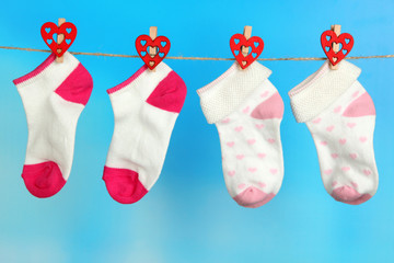 Socks hanging on clothesline on bright background