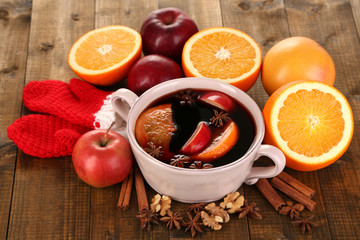 Fragrant mulled wine in pan on wooden table close-up