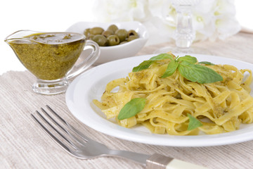Delicious pasta with pesto on plate on table close-up