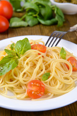 Delicious spaghetti with tomatoes on plate on table close-up