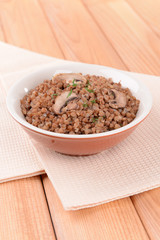 Boiled buckwheat in bowl on table close-up