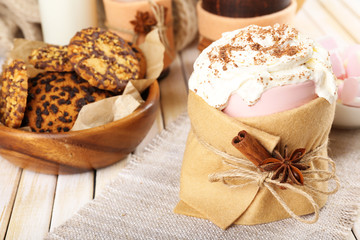 Mug of hot drink decorated in felt on wooden table