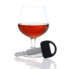 Composition with car key and glass of cognac, isolated on white