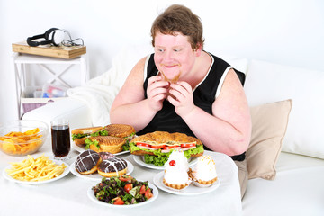 Fat man has a big lunch, on home interior background