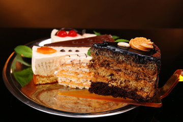Assortment of pieces of cake, on dark background © Africa Studio