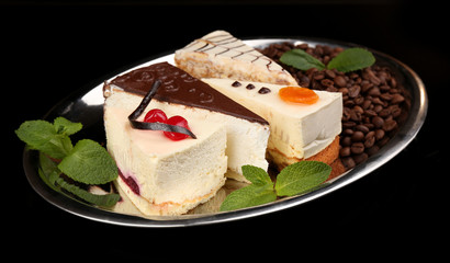 Assortment of pieces of cake, on dark background © Africa Studio