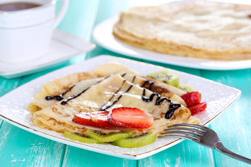 Delicious pancakes with strawberries and chocolate
