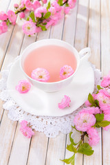 Beautiful fruit blossom with cup of tea on table close-up