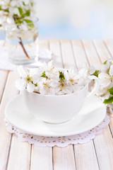 Fototapeta na wymiar Beautiful fruit blossom in glass on table on light background