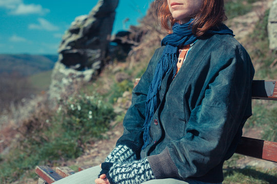 Woman relaxing on a bench in the mountains