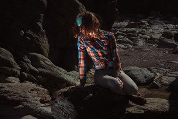 Naklejka premium Woman sitting on a rock