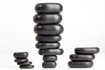 Shiny smooth Black massage stones stacked on top of each other