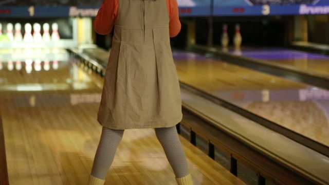 bowling - a little girl knocks down pins and very glad