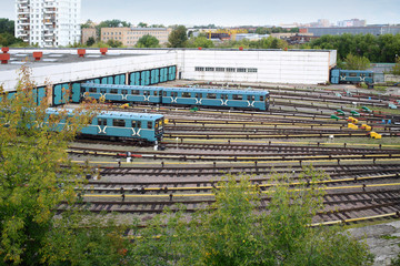 Two city underground trains leave the depot gates