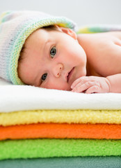 newborn baby girl  lying on colourful towels