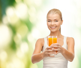 smiling woman holding glass of orange juice
