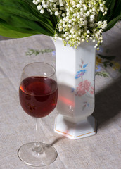 lily of the valley in vase and glass of wine