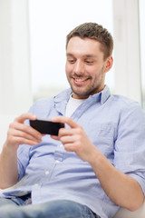 smiling man with smartphone at home