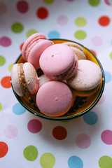 macaroons in a yellow bowl on color background