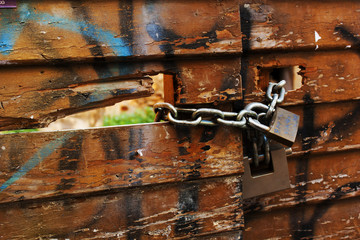 old lock and chain around wooden fence
