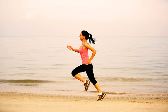 young fitness woman runner athlete running on beach