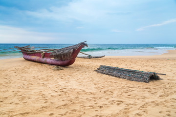 Obraz na płótnie Canvas Traditional Sri Lankan fishing boat on empty sandy beach.