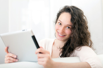 Portrait of a young attractive woman using tablet on sofa