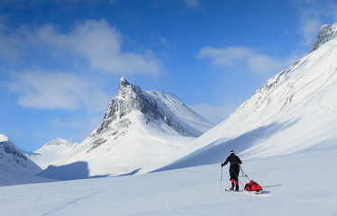 Crosscountry skier with pulka in the snow in Sweden.