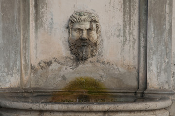 A small fountain with man face in Vatican