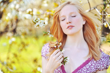 Fototapeta premium Beautiful healthy young girl in blooming tree. Eyes closed