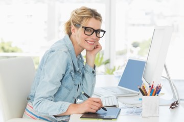 Blonde pretty designer looking at the camera using digitizer