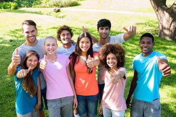 Happy friends gesturing thumbs up