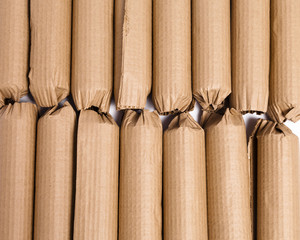 Cylindrical cardboard tubes used for packaging and shipping make a background of two horizontal rows.