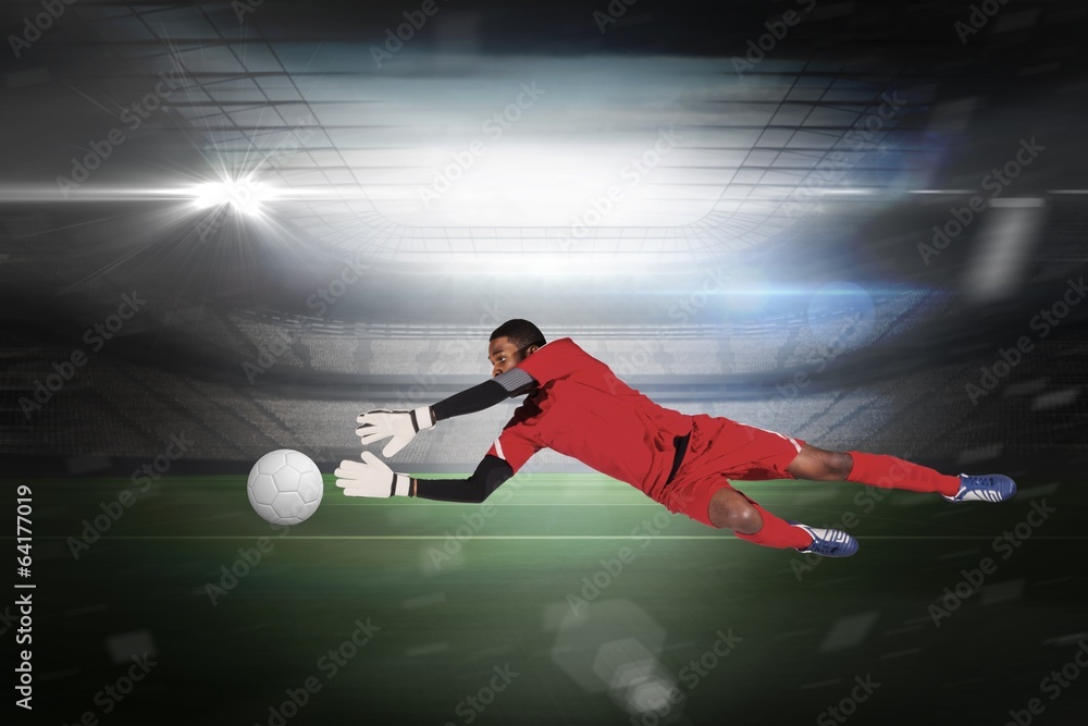 Fototapete composite image of goalkeeper in red making a save