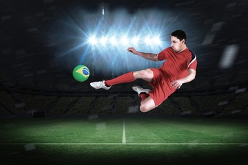 Fototapeta na wymiar Composite image of fit football player jumping and kicking