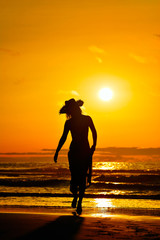 young woman silhouette on the beach in summer