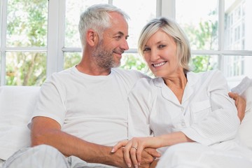 Portrait of a mature couple sitting in bed