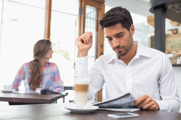 Man reading newspaper in coffee shop