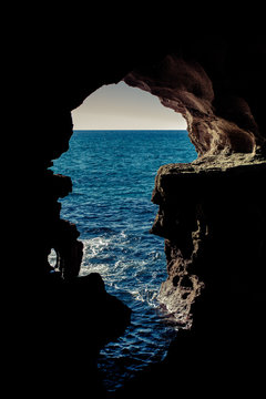 View of the Atlantic ocean through a large hole in the cave