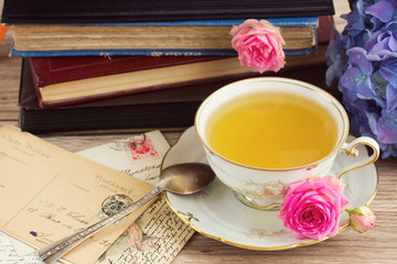old books and mail with cup of tea