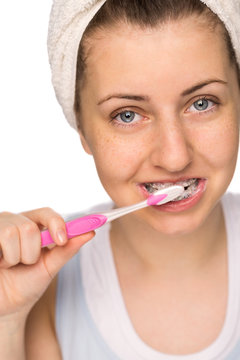 Girl with braces brushing teeth isolated