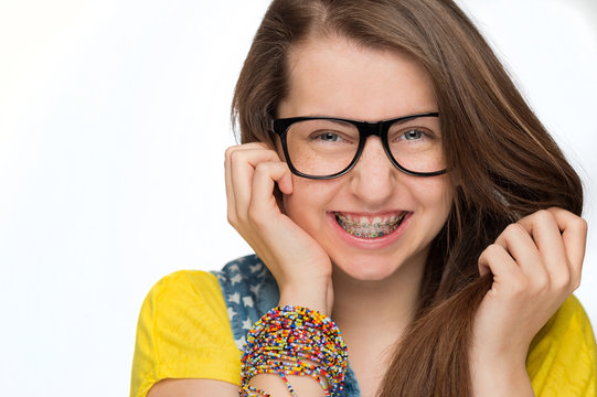 Girl with braces wearing geek glasses isolated