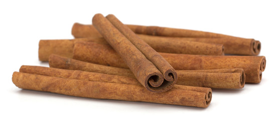cinnamon sticks stacked on white background