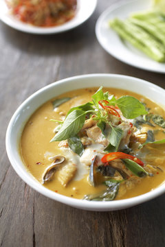 spicy fish curry with chili and coconut sauce on table